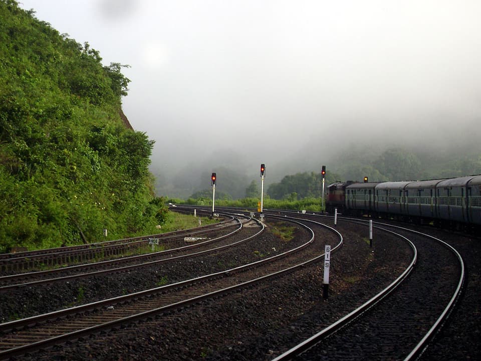 A passenger train winding through misty Eastern Ghats near Laxmipur Road